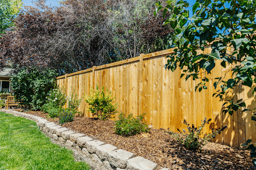 A newly installed wooden fence constructed by Butte Fence in a backyard, offering both privacy and a charming rustic element.